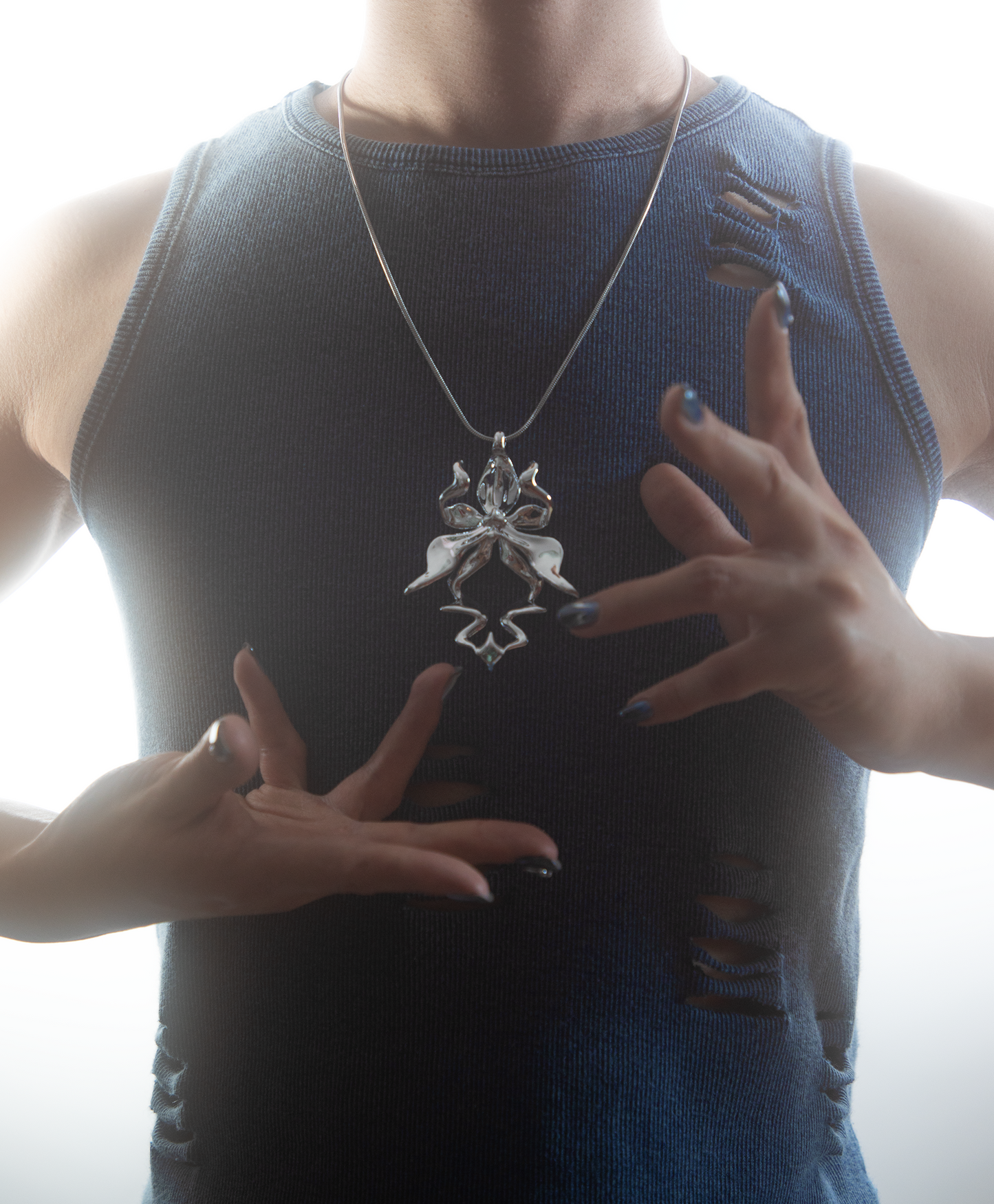 Model wearing silver-plated 3D printed resin orchid necklace with gemstone
